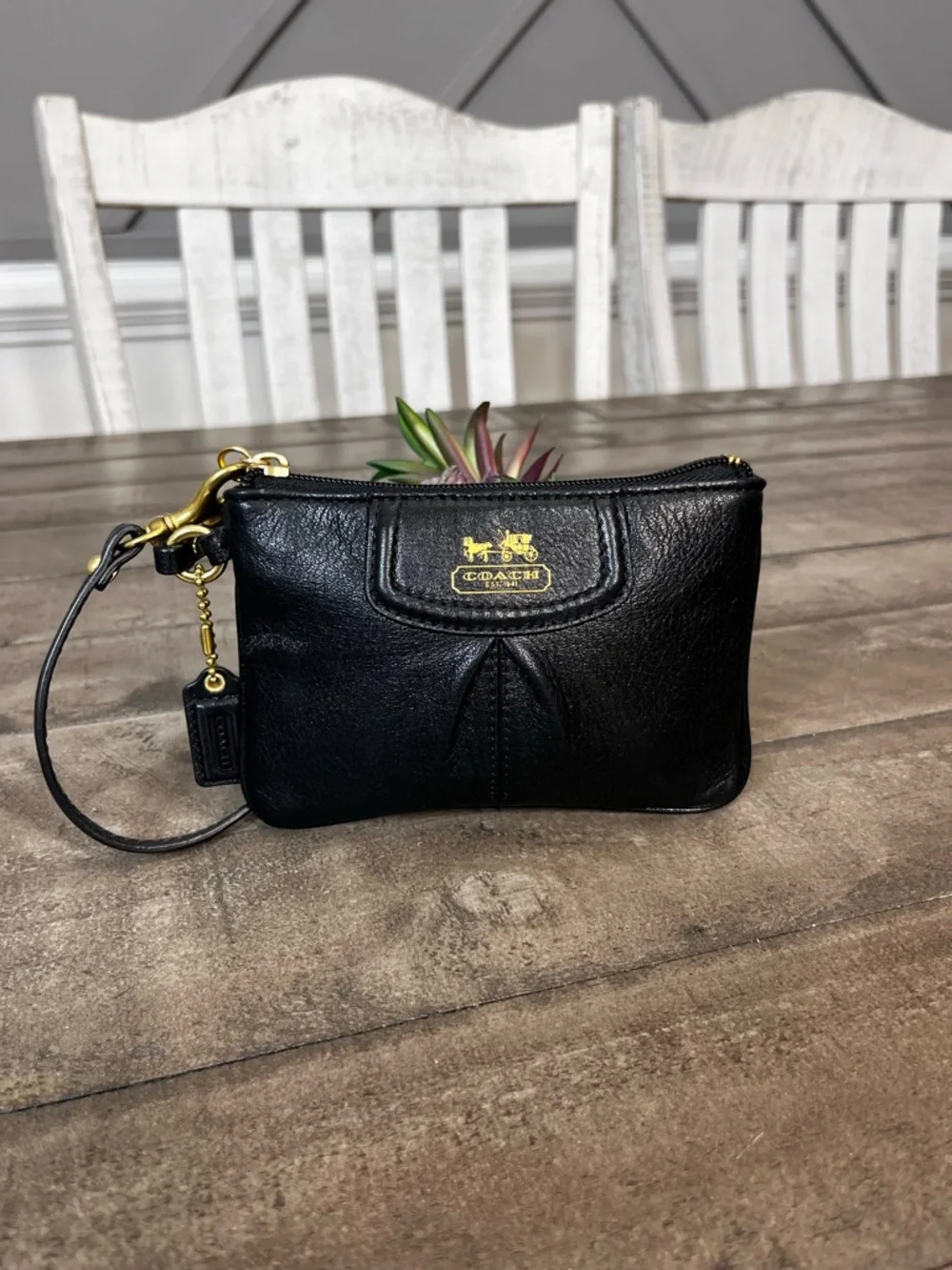 Madison black pebbled leather wristlet featuring gold-tone‎ hardware